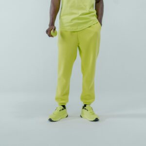 Close-up image featuring a person in neon green sportswear and sneakers against a white backdrop.